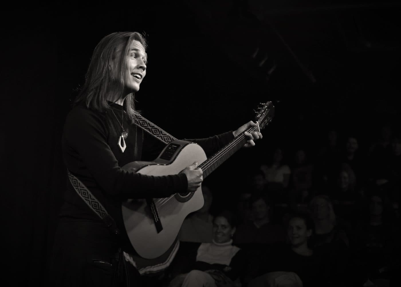Performing with guitar to a seated audience at Mezrab, Amsterdam
